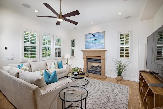 living room featuring recessed lighting, plenty of natural light, baseboards, and a glass covered fireplace