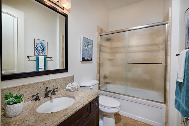 bathroom with toilet, combined bath / shower with glass door, and vanity