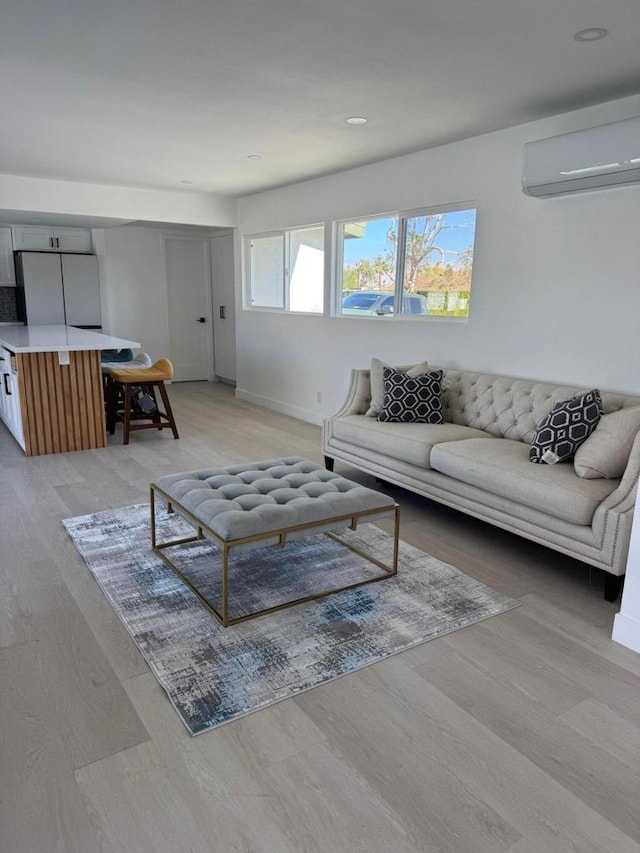 living room with light hardwood / wood-style flooring and a wall mounted air conditioner