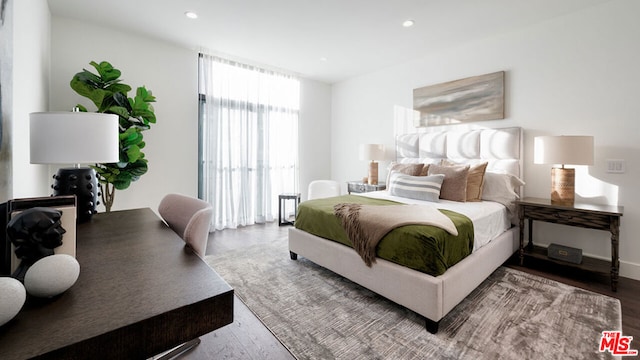 bedroom with floor to ceiling windows and wood-type flooring