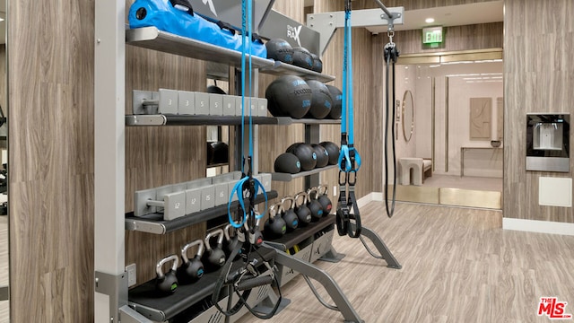 exercise area with wood-type flooring and wood walls