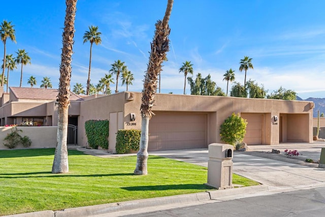 pueblo-style house featuring a front yard and a garage