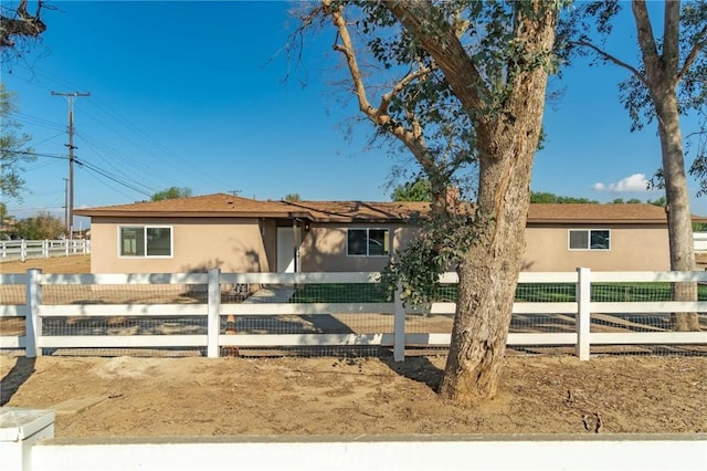 ranch-style house with a fenced front yard and stucco siding