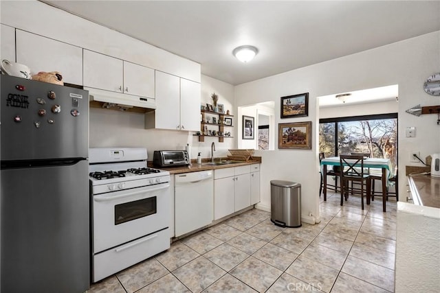 kitchen with light tile patterned floors, sink, white cabinets, and white appliances