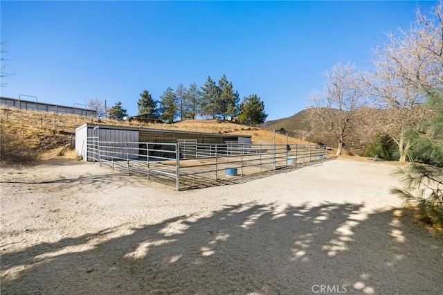 view of stable with a rural view and a mountain view