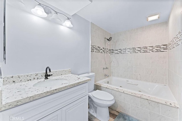 full bathroom with toilet, tiled shower / bath, and vanity