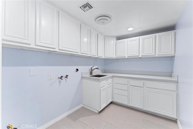 washroom with cabinets, sink, hookup for a washing machine, and light tile patterned flooring