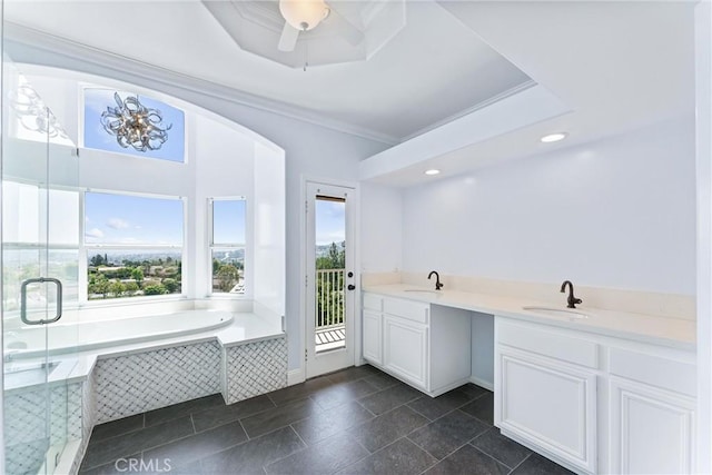 bathroom with a relaxing tiled tub, a wealth of natural light, vanity, and crown molding