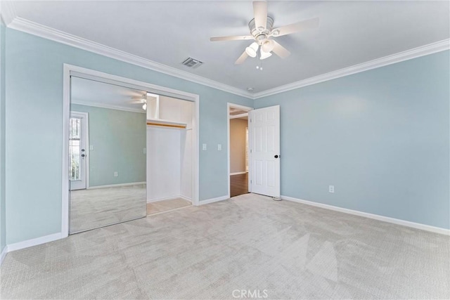 unfurnished bedroom with ceiling fan, a closet, and crown molding