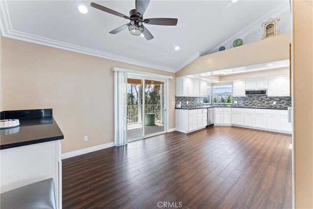 kitchen featuring ceiling fan, tasteful backsplash, vaulted ceiling, sink, and white cabinetry