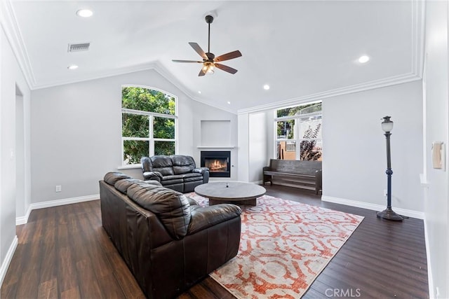 living room with ceiling fan, dark hardwood / wood-style flooring, ornamental molding, and vaulted ceiling