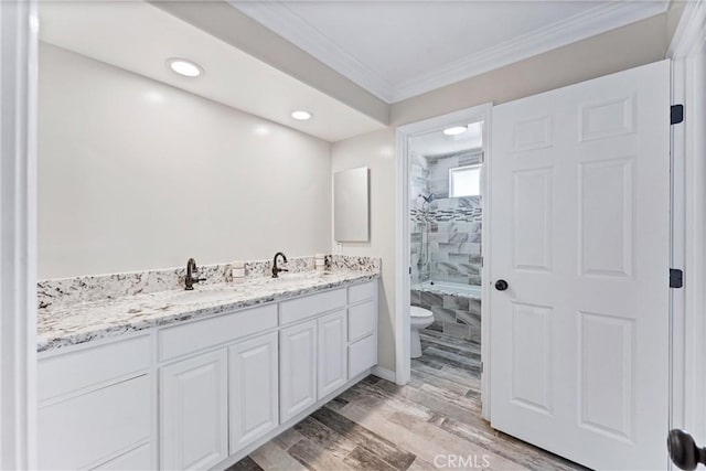 full bathroom featuring toilet, tiled shower / bath combo, wood-type flooring, crown molding, and vanity