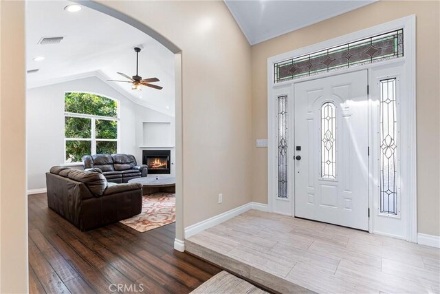 foyer entrance with ceiling fan, light hardwood / wood-style flooring, and vaulted ceiling