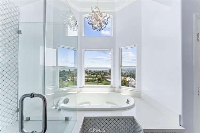 bathroom featuring a chandelier, a tub to relax in, and ornamental molding