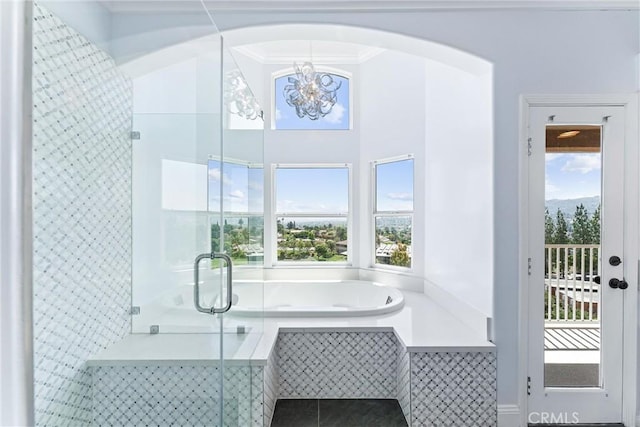 bathroom with crown molding, an inviting chandelier, and shower with separate bathtub