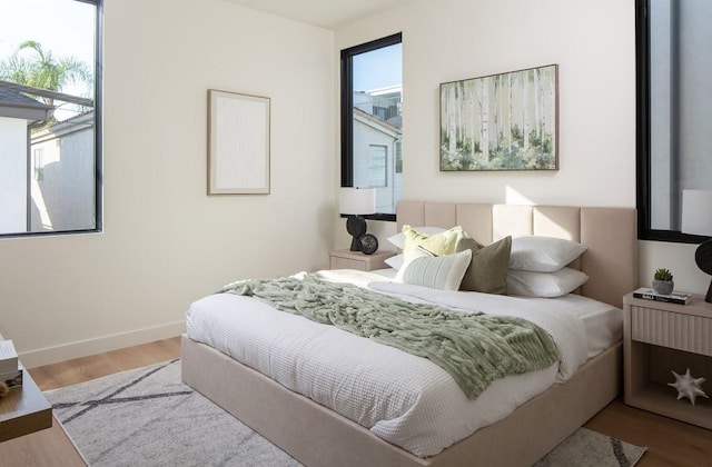 bedroom with hardwood / wood-style flooring and multiple windows