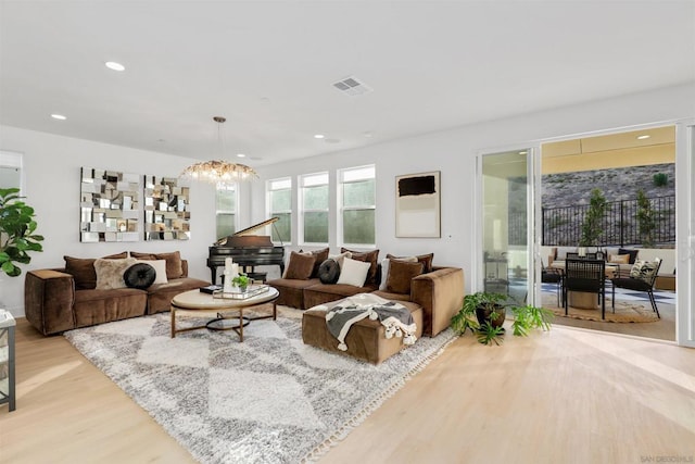 living room featuring a chandelier and light hardwood / wood-style flooring