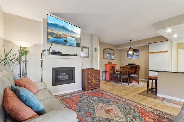 living room featuring ceiling fan and hardwood / wood-style flooring