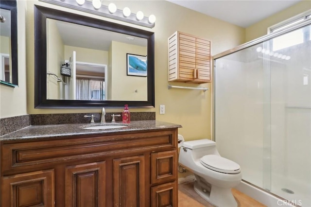 bathroom with toilet, vanity, and walk in shower