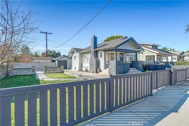 view of front of house featuring a storage unit and a front yard