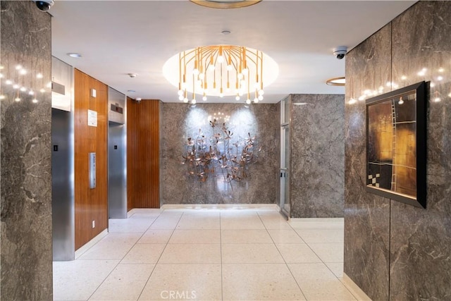 interior space with light tile patterned floors, wooden walls, and a chandelier