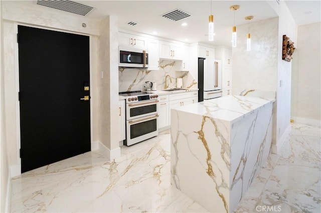 kitchen with pendant lighting, sink, white appliances, white cabinets, and light stone counters