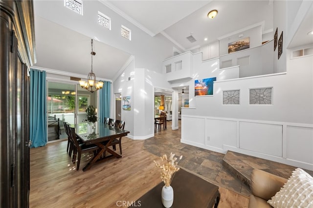 dining area featuring high vaulted ceiling, an inviting chandelier, and crown molding