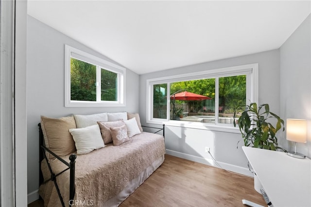 bedroom with lofted ceiling and light wood-type flooring