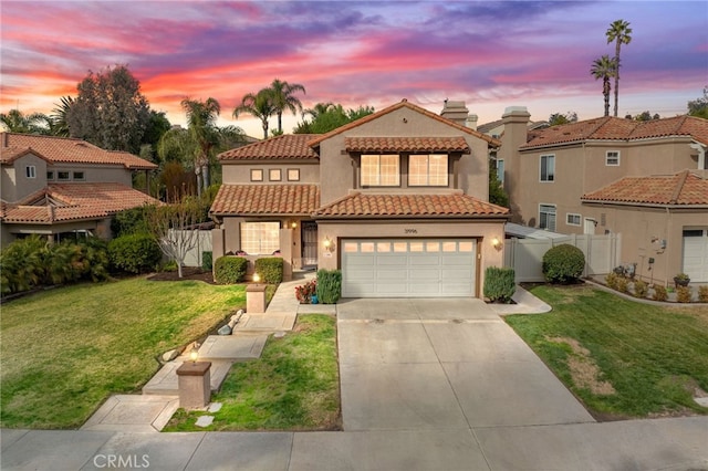 mediterranean / spanish-style house with a garage and a lawn