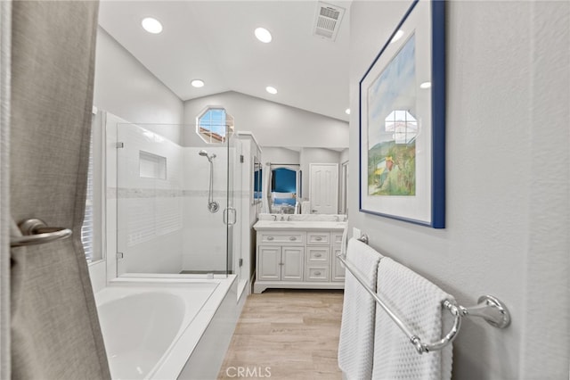 bathroom featuring lofted ceiling, vanity, separate shower and tub, and hardwood / wood-style flooring