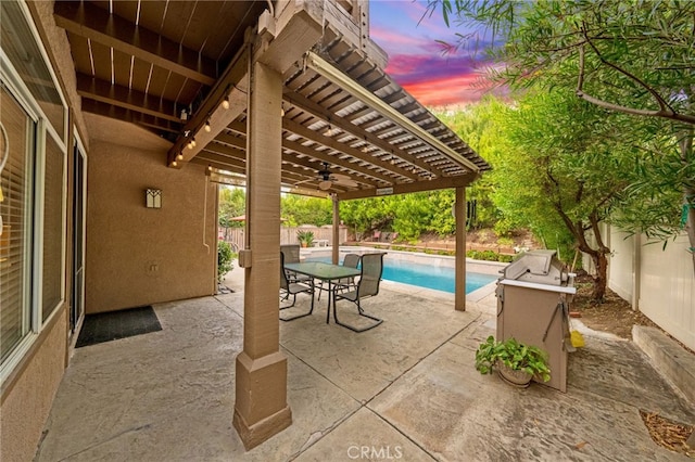 patio terrace at dusk with a pergola and a fenced in pool