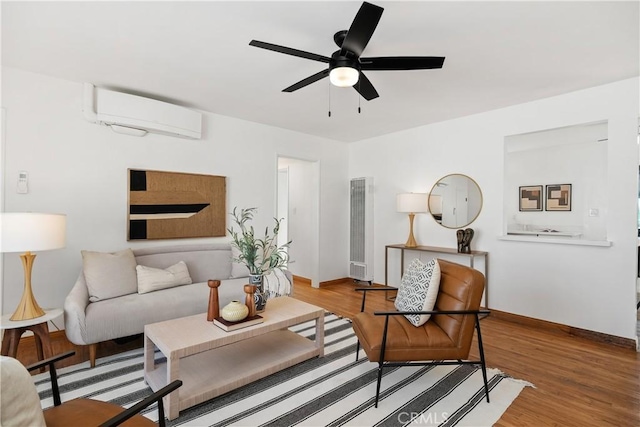 living room with an AC wall unit, hardwood / wood-style flooring, and ceiling fan