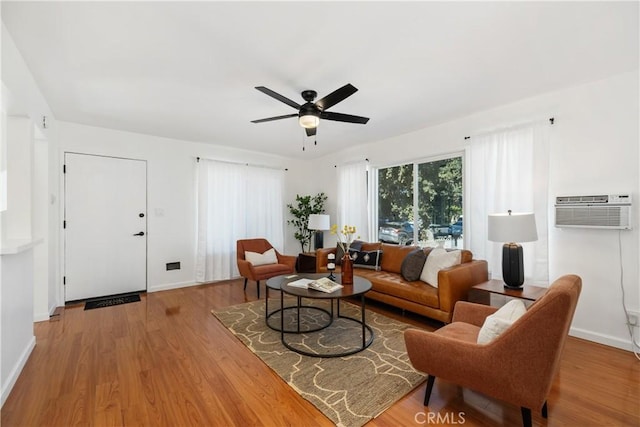 living room featuring ceiling fan, wood-type flooring, and a wall mounted air conditioner