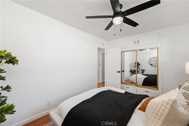 bedroom featuring ceiling fan, a closet, and wood-type flooring