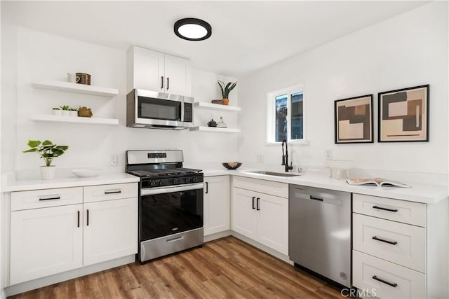 kitchen with white cabinets, dark hardwood / wood-style floors, sink, and stainless steel appliances