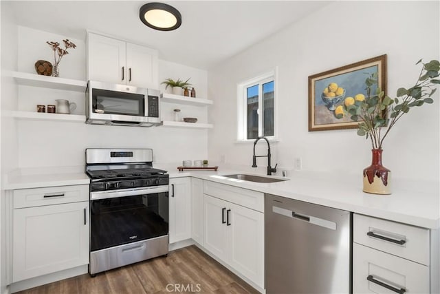 kitchen with sink, white cabinetry, dark hardwood / wood-style floors, and stainless steel appliances