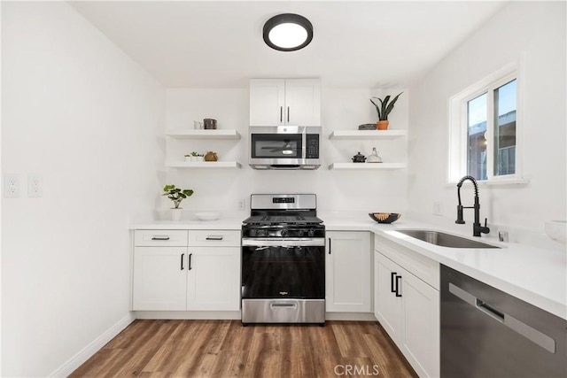 5536 Linden Ave, Long Beach, CA 90805 - kitchen featuring appliances with stainless steel finishes, open shelves, wood finished floors, a sink, and white cabinetry
