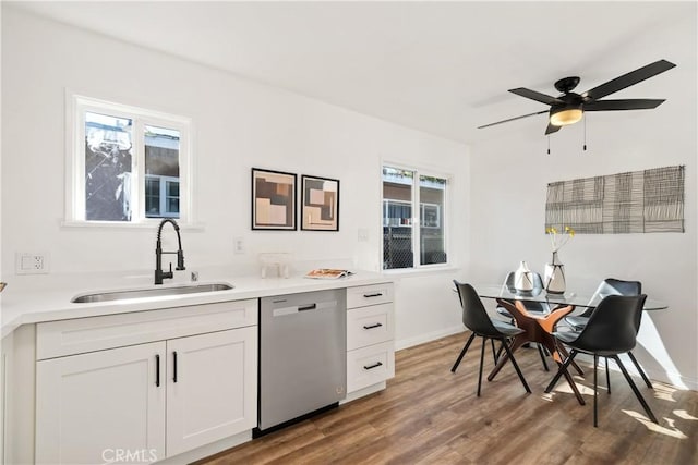 kitchen featuring white cabinetry, hardwood / wood-style floors, ceiling fan, stainless steel dishwasher, and sink