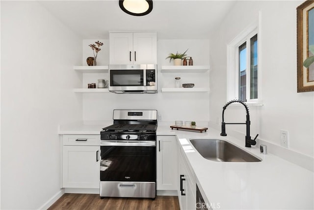 kitchen featuring dark hardwood / wood-style floors, appliances with stainless steel finishes, white cabinetry, and sink