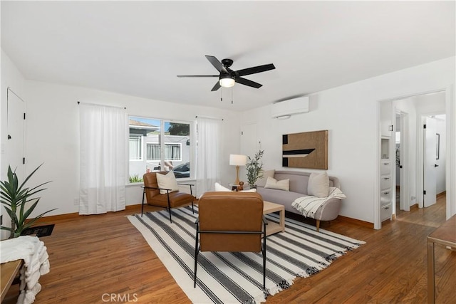 living room featuring ceiling fan, wood-type flooring, and a wall mounted AC