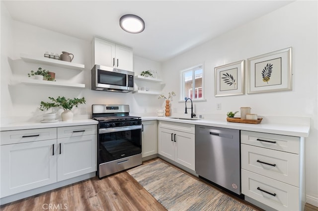 5536 Linden Ave, Long Beach, CA 90805 - kitchen with open shelves, wood finished floors, light countertops, a sink, and appliances with stainless steel finishes