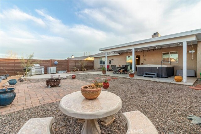 21246 Wren St, Apple Valley, CA 92308 - view of patio with an outdoor fire pit, a fenced backyard, and a hot tub