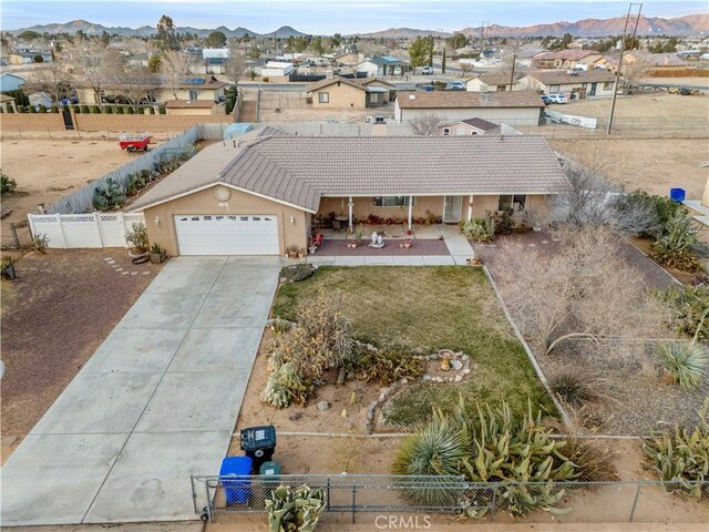 21246 Wren St, Apple Valley, CA 92308 - view of front of property featuring driveway, stucco siding, a garage, fence private yard, and a mountain view