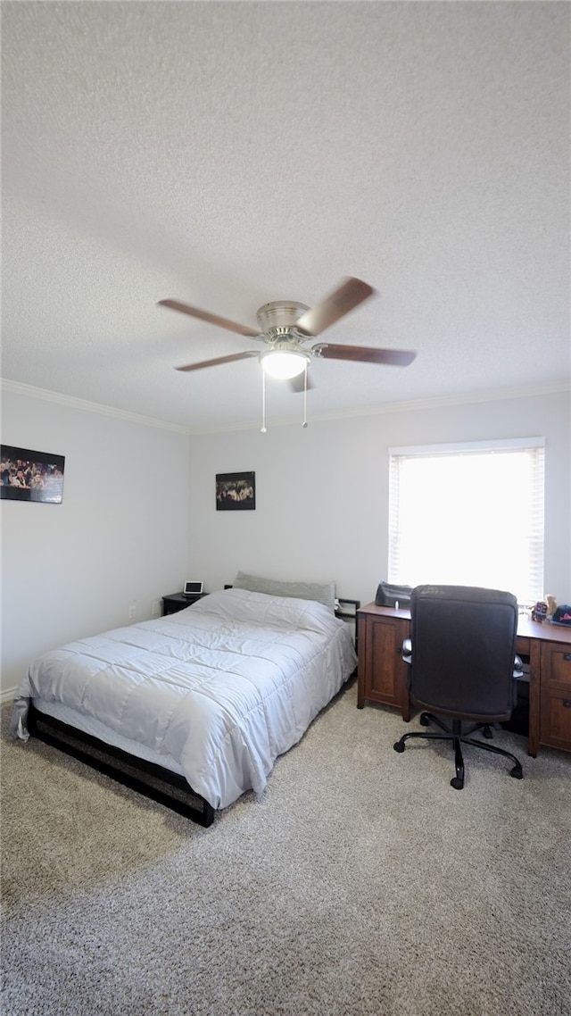 bedroom with ceiling fan, crown molding, light colored carpet, and a textured ceiling