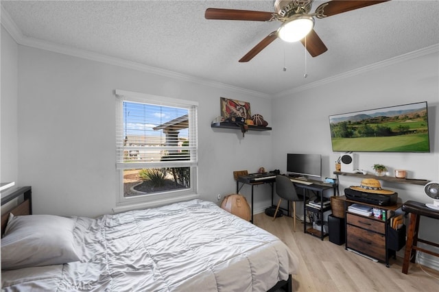 bedroom with ceiling fan, crown molding, light hardwood / wood-style floors, and a textured ceiling