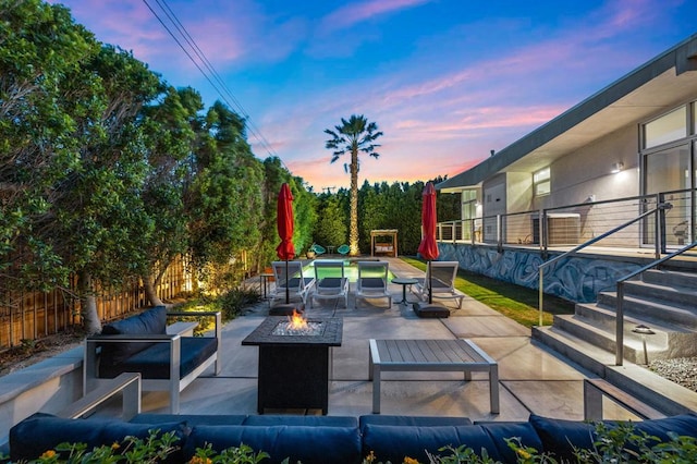 patio terrace at dusk with an outdoor living space with a fire pit