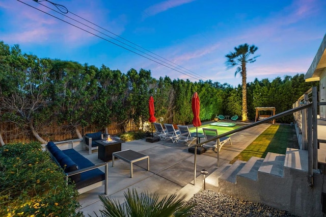 patio terrace at dusk featuring an outdoor fire pit