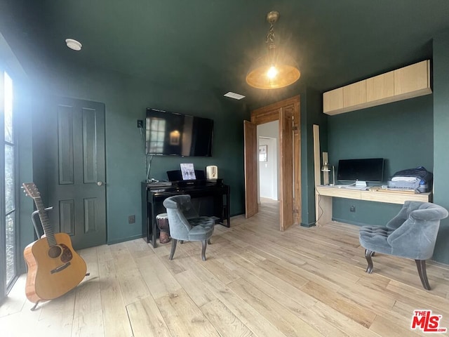 home office with built in desk and light wood-type flooring