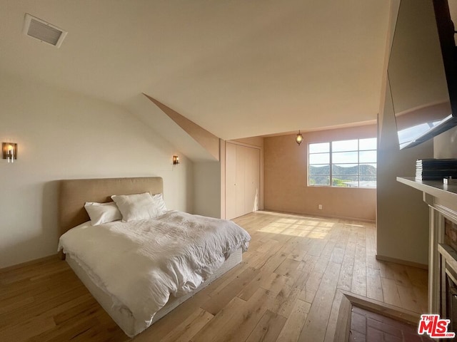 bedroom featuring vaulted ceiling and light hardwood / wood-style floors