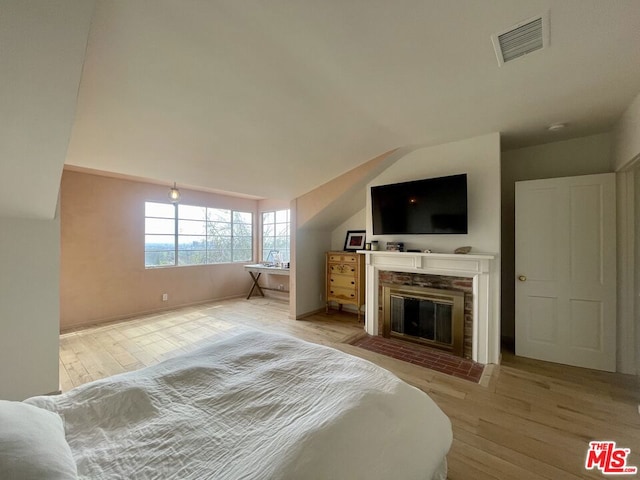 bedroom featuring light hardwood / wood-style floors and vaulted ceiling